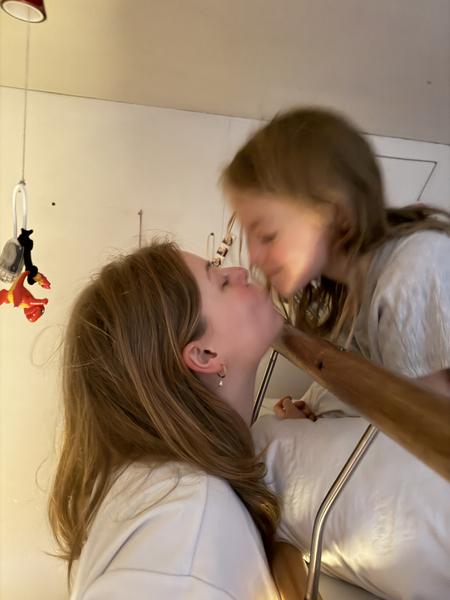 This intimate photo captures two individuals sharing a tender moment indoors, likely in a home interior in Oudeschans, Uilenburg, Amsterdam